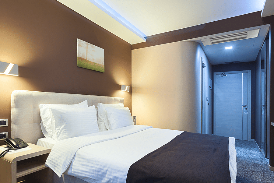 Compact ceiling cassette air conditioner for hotel rooms.