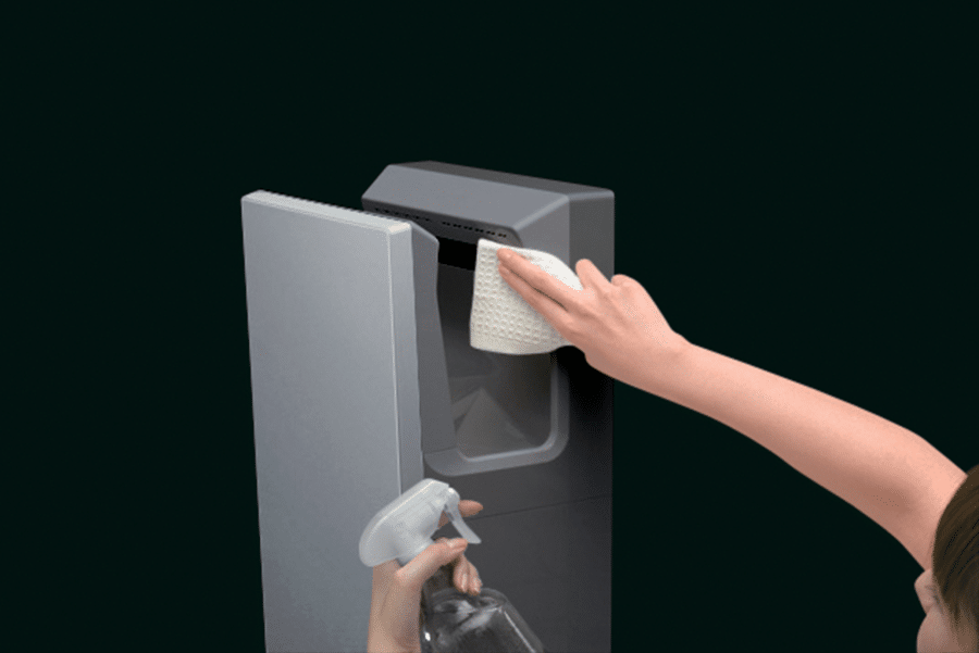 Person cleaning a Mitsubishi Electric Jet Towel Slim electric hand dryer, showing accessible surfaces, antibacterial resin finish and removable water tank.