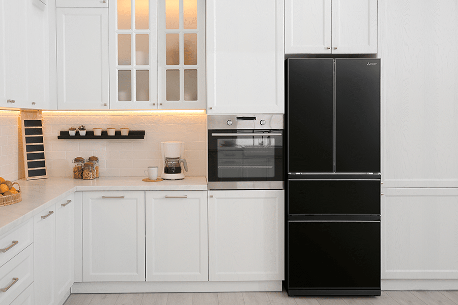 Striking modern kitchen featuring a sophisticated Mitsubishi Electric MR-LX442EX Brilliant Black French door refrigerator that commands attention as the centrepiece, perfectly complemented by crisp white cabinetry with elegant glass-front display doors, warm under-cabinet LED lighting casting a golden glow across the pristine stone benchtop, and seamlessly integrated stainless steel appliances creating a harmonious blend of contemporary design and premium functionality