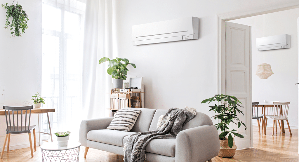 Modern open-plan home with two Mitsubishi Electric wall-mounted indoor air conditioning units in the living and dining areas, demonstrating a multi split system setup